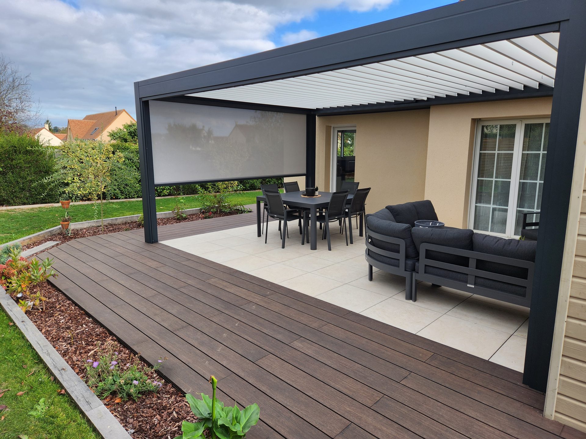 Terrasse associant lames et carrelage sous une pergola