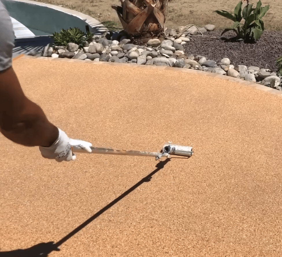 Finition d'une plage de piscine en moquette de pierre