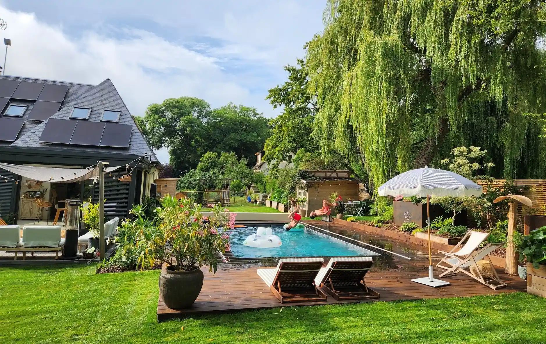 Piscine creusée en béton avec terrasse bois et aménagements extérieurs