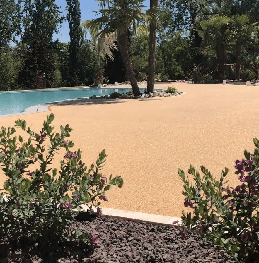 Plage de piscine en moquette de pierre dans un jardin